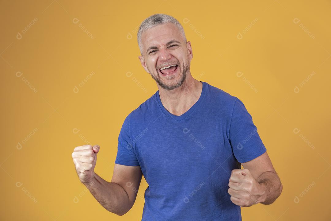 Homem brasileiro de meia idade vestindo roupas casuais comemorando