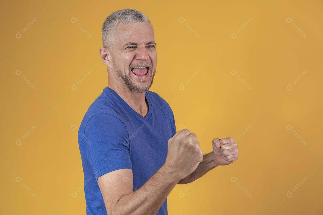 Homem brasileiro de meia idade vestindo roupas casuais comemorando