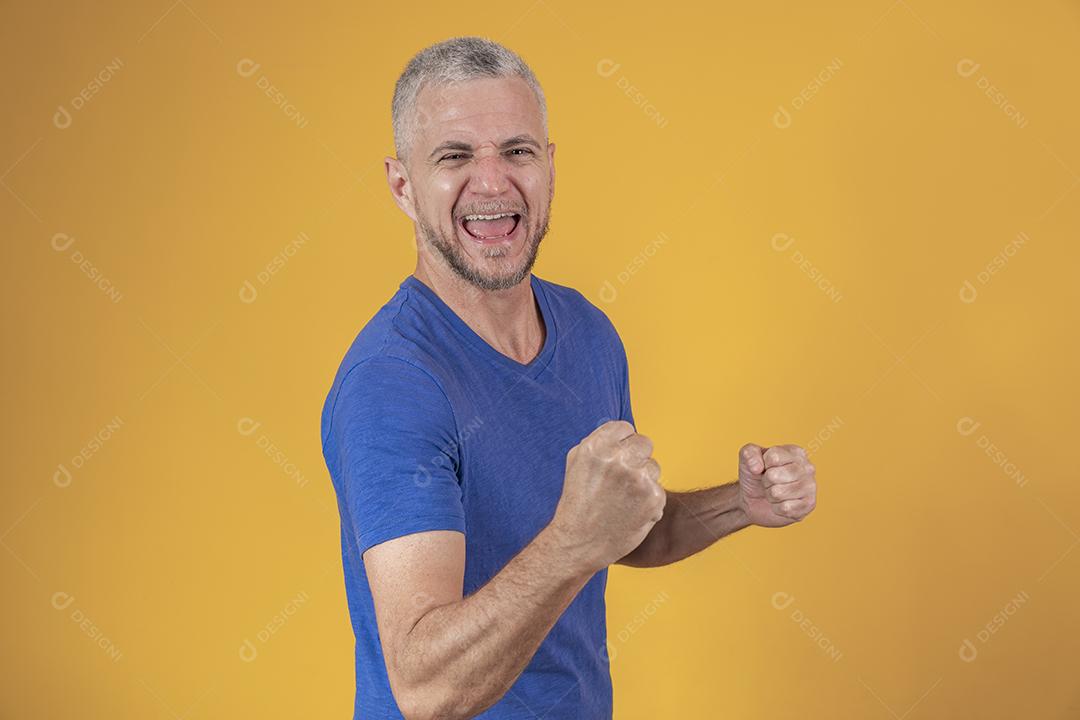 Homem brasileiro de meia idade vestindo roupas casuais comemorando