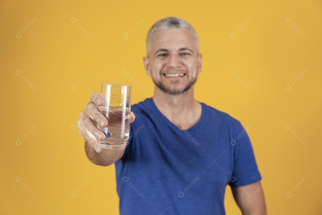 Homem de meia idade segurando copo de água