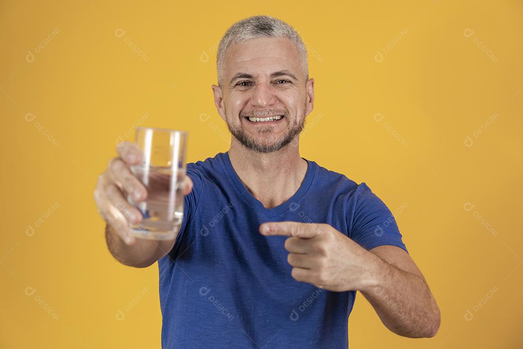 Homem de meia idade segurando copo de água