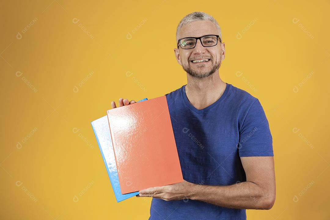 Homem de meia idade estudando com cadernos na mão