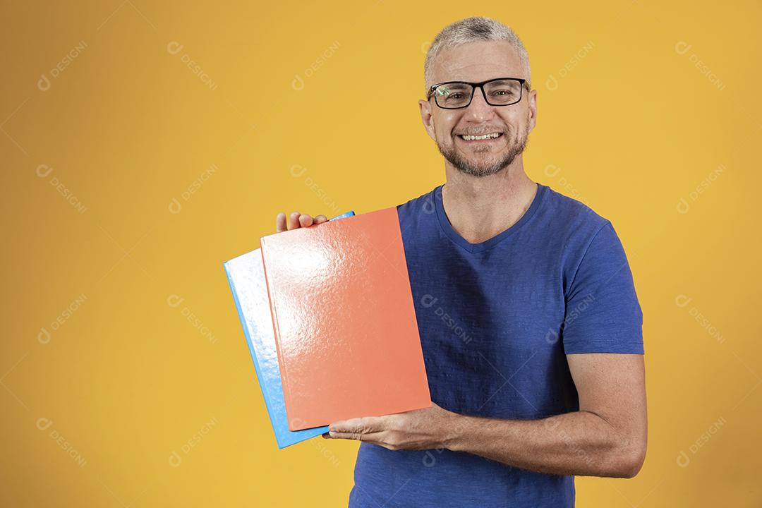 Homem de meia idade estudando com cadernos na mão