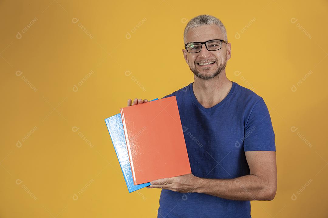 Homem de meia idade estudando com cadernos na mão