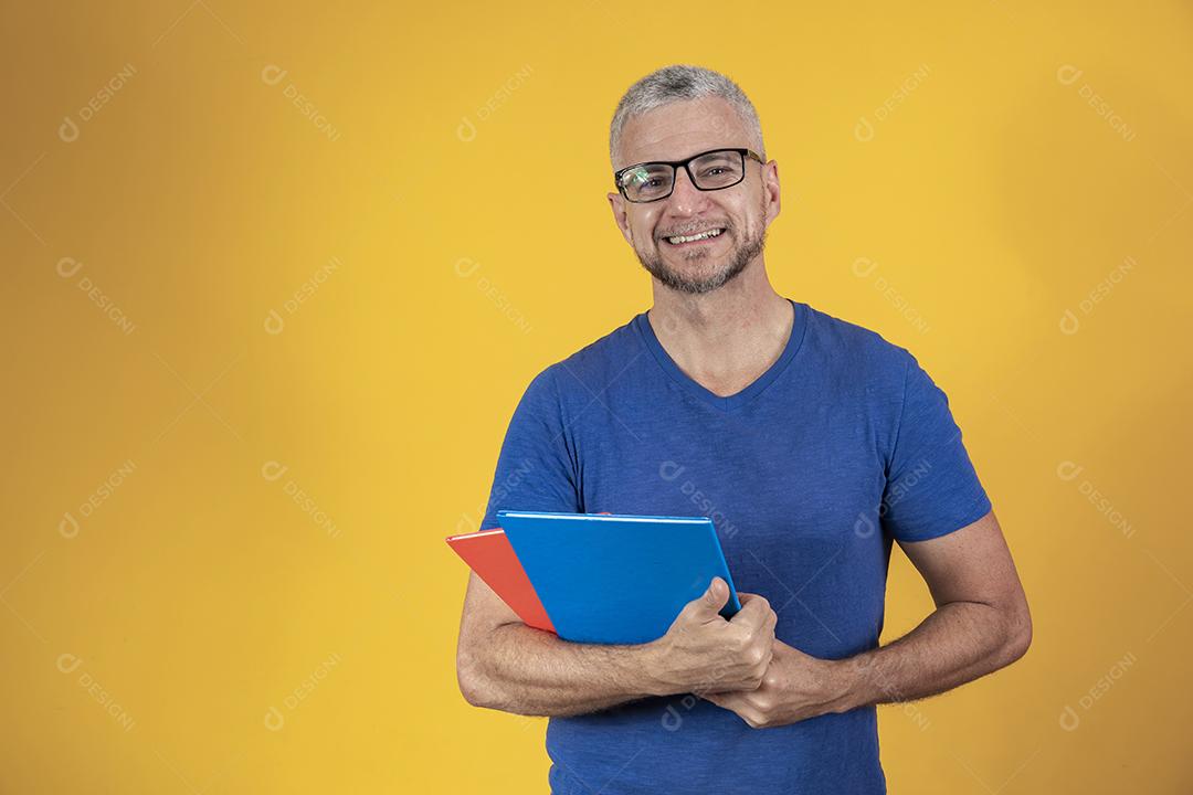 Homem de meia idade estudando com cadernos na mão