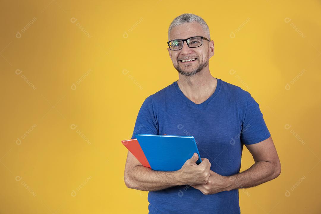 Homem de meia idade estudando com cadernos na mão