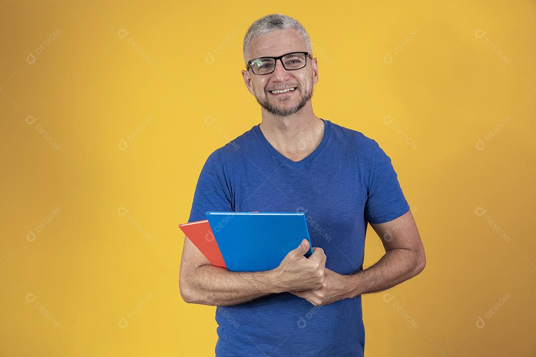 Homem de meia idade estudando com cadernos na mão