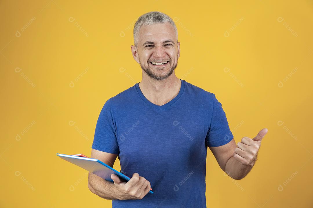 Homem de meia idade estudando com cadernos na mão