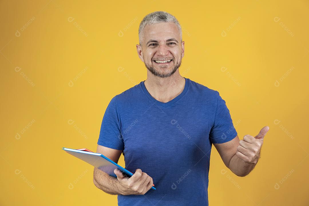 Homem de meia idade estudando com cadernos na mão