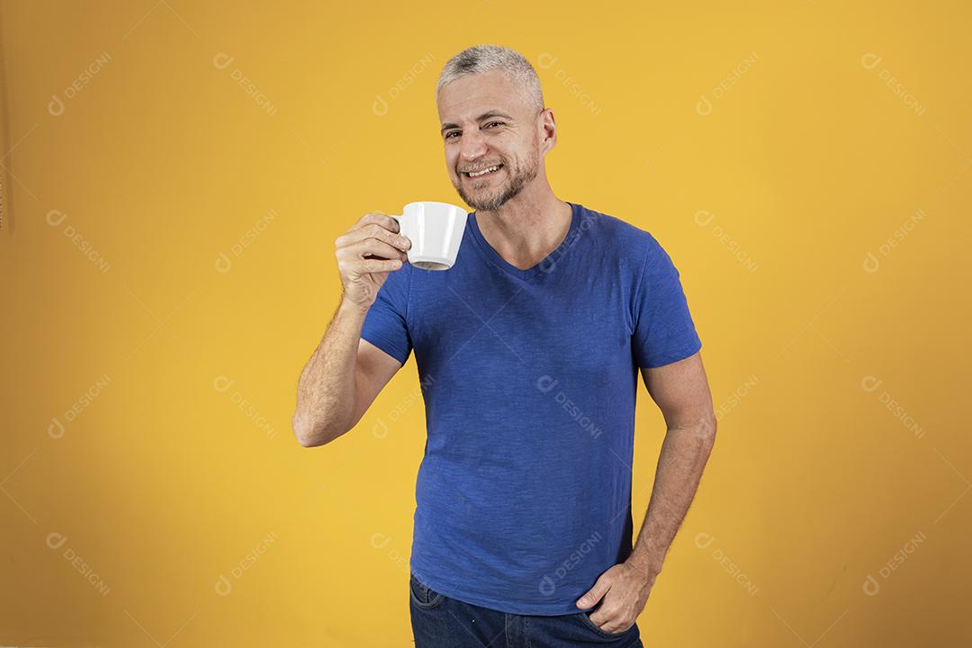 Homem maduro de meia idade tomando um café