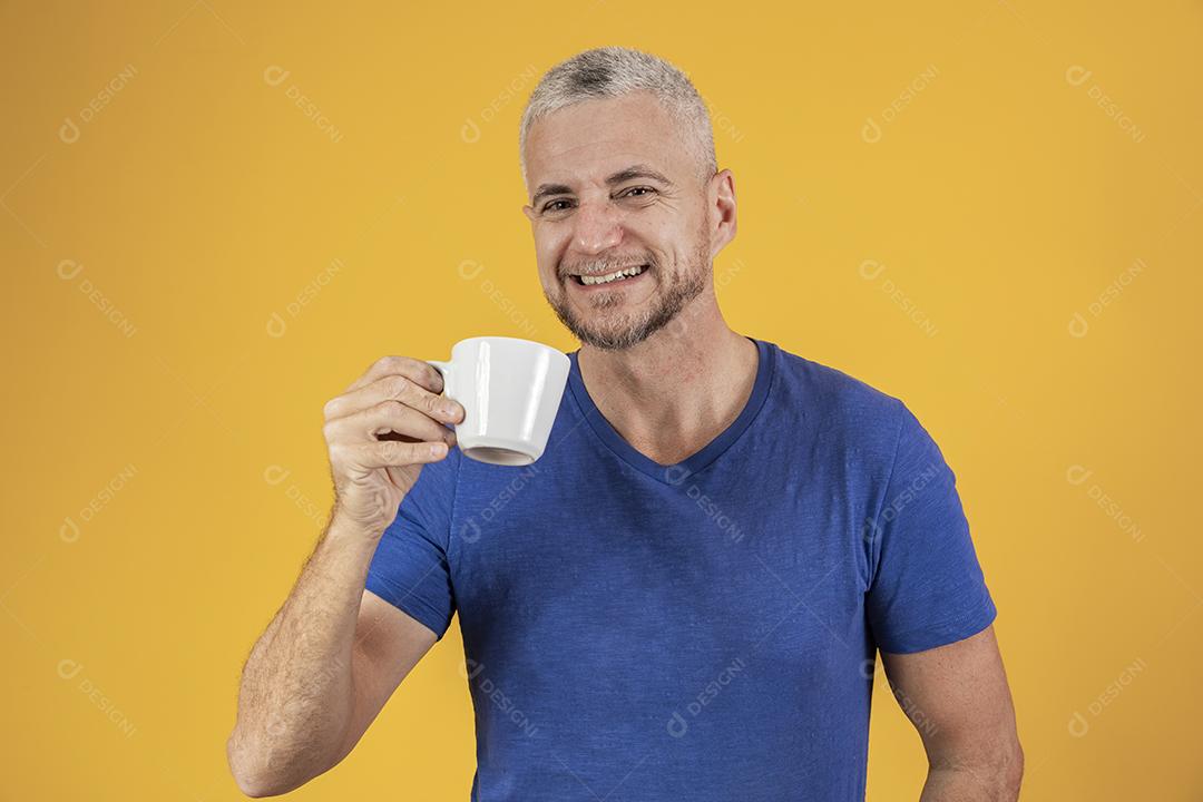 Homem maduro de meia idade tomando um café