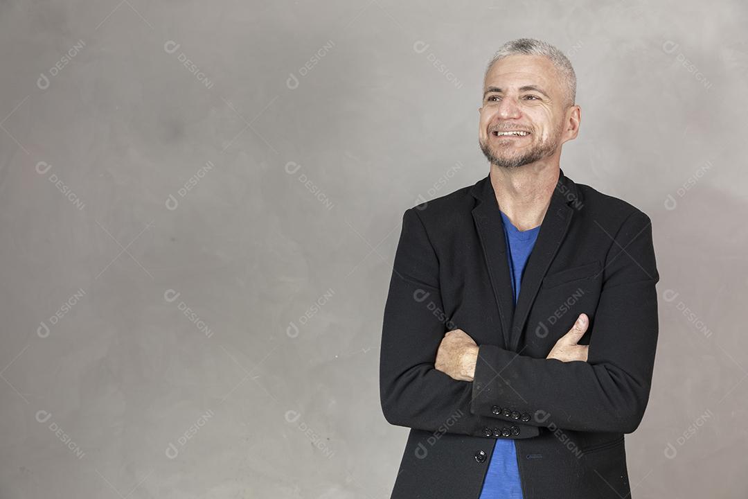 Homem de meia idade sorrindo com braços cruzados
