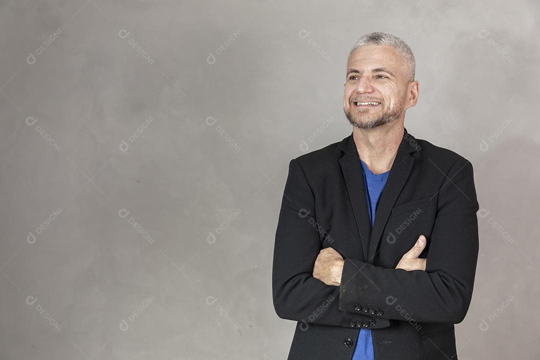 Homem de meia idade sorrindo com braços cruzados