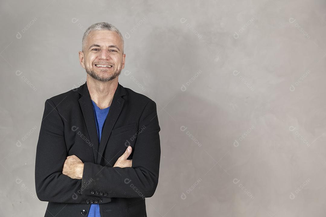 Homem de meia idade sorrindo com braços cruzados