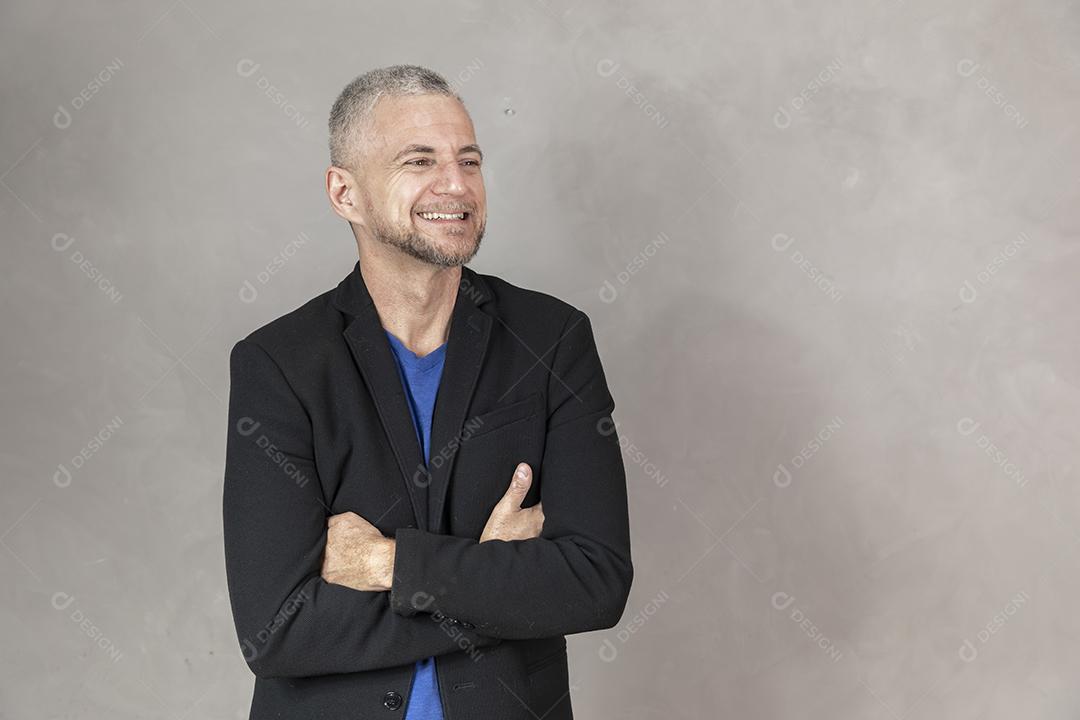 Homem de meia idade sorrindo com braços cruzados