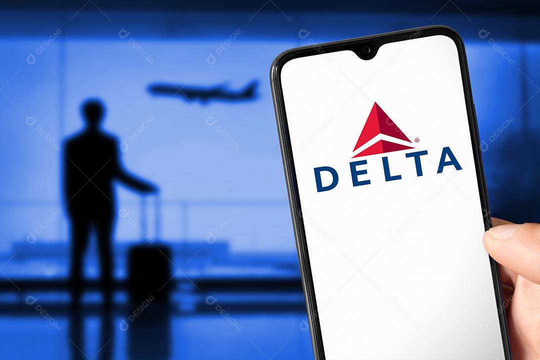 Logotipo da Delta Airlines na tela do smartphone com aeronaves de aparência humana no aeroporto, 23 de junho de 2022, São Paulo, Brasil.