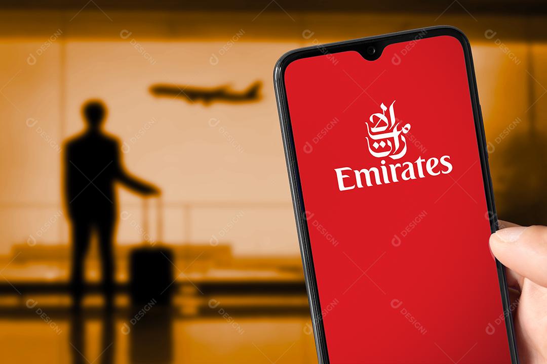 Logotipo da Emirates na tela do smartphone com aeronaves de aparência humana no aeroporto, 23 de junho de 2022, São Paulo, Brasil.