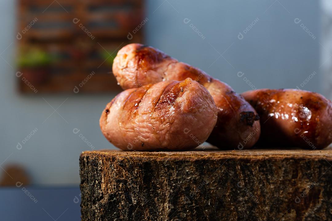 tradicional linguiça de churrasco brasileira com marcas de grelha, mas que ressecaram com o tempo. em cima de uma superfície de madeira