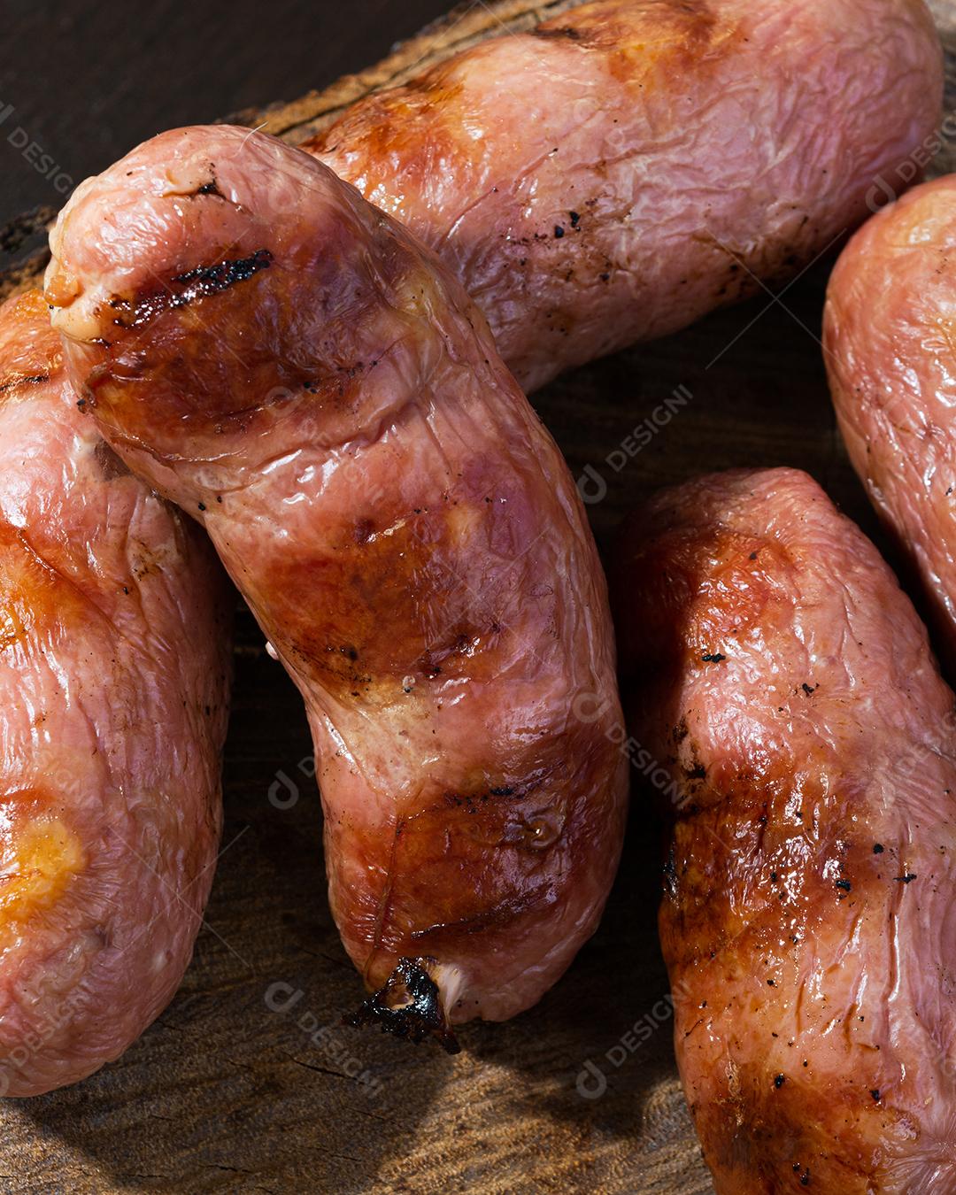 tradicional linguiça de churrasco brasileira com marcas de grelha, mas que ressecaram com o tempo. em cima de uma superfície de madeira