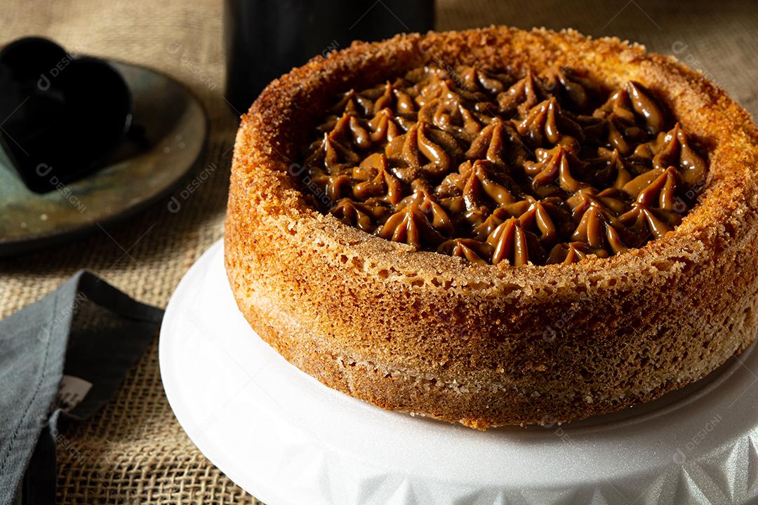 bolo de churros brasileiro típico com doce de leite, em uma mesa com pratos e café, café da manhã confortável ou cena de lanche