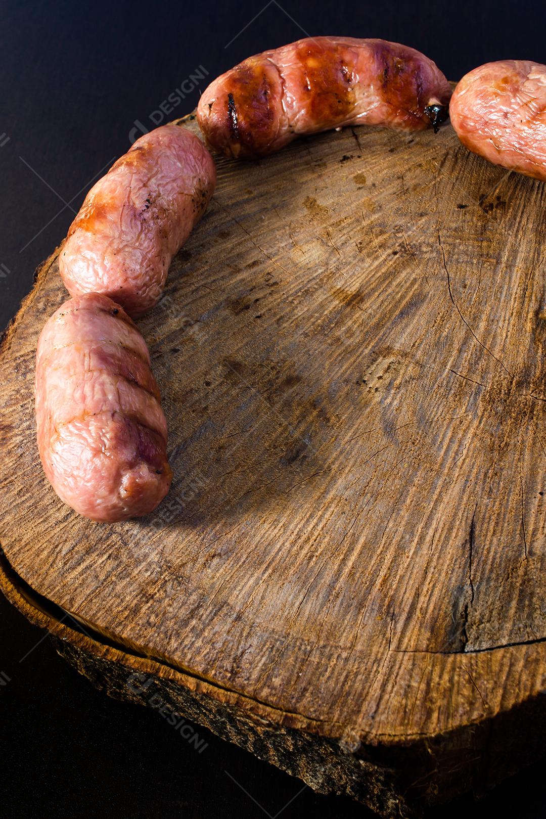 traditional Brazilian barbecue sausage with grill marks, but which dried out over time. on top of a wooden surface