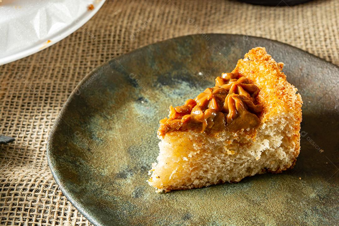 bolo de churros brasileiro típico com doce de leite, em uma mesa com pratos e café, café da manhã confortável ou cena de lanche