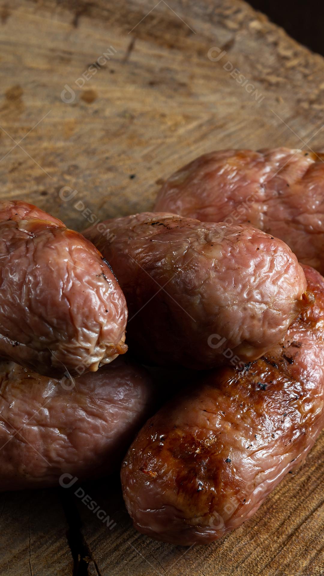 tradicional linguiça de churrasco brasileira com marcas de grelha, mas que ressecaram com o tempo. em cima de uma superfície de madeira