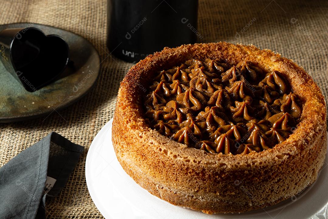 bolo de churros brasileiro típico com doce de leite, em uma mesa com pratos e café, café da manhã confortável ou cena de lanche