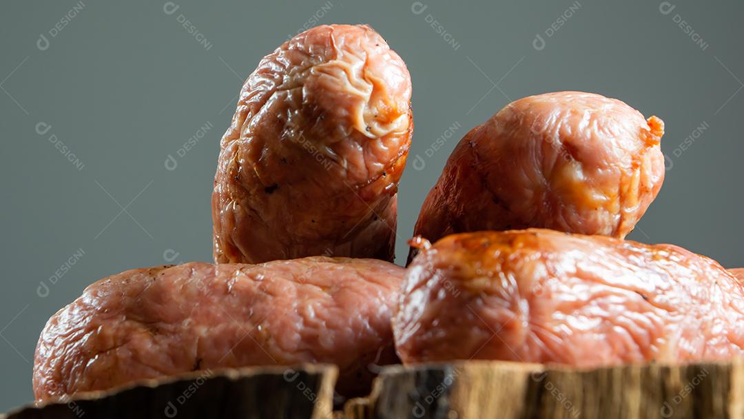 tradicional linguiça de churrasco brasileira com marcas de grelha, mas que ressecaram com o tempo. em cima de uma superfície de madeira