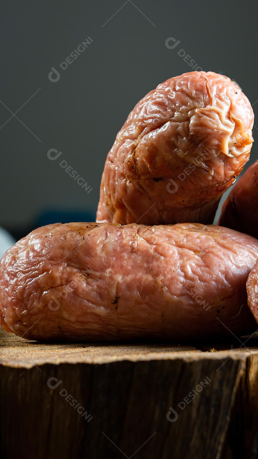 tradicional linguiça de churrasco brasileira com marcas de grelha, mas que ressecaram com o tempo. em cima de uma superfície de madeira