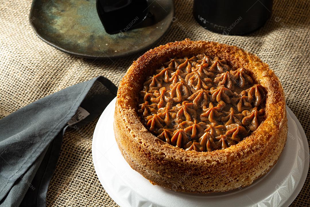 bolo de churros brasileiro típico com doce de leite, em uma mesa com pratos e café, café da manhã confortável ou cena de lanche