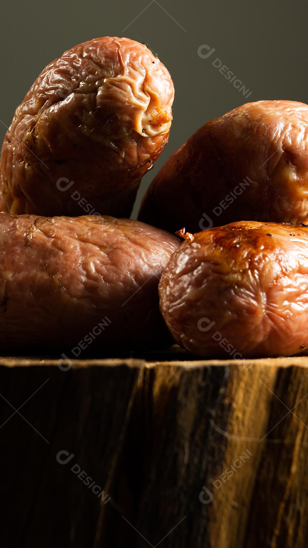 tradicional linguiça de churrasco brasileira com marcas de grelha, mas que ressecaram com o tempo. em cima de uma superfície de madeira