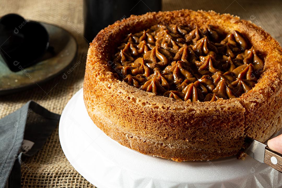 bolo de churros brasileiro típico com doce de leite, em uma mesa com pratos e café, café da manhã confortável ou cena de lanche