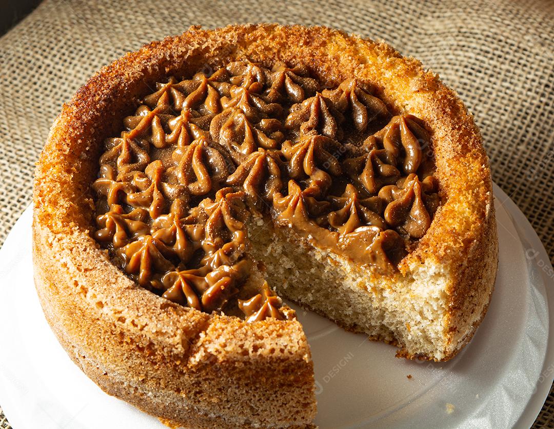 bolo de churros brasileiro típico com doce de leite, em uma mesa com pratos e café, café da manhã confortável ou cena de lanche