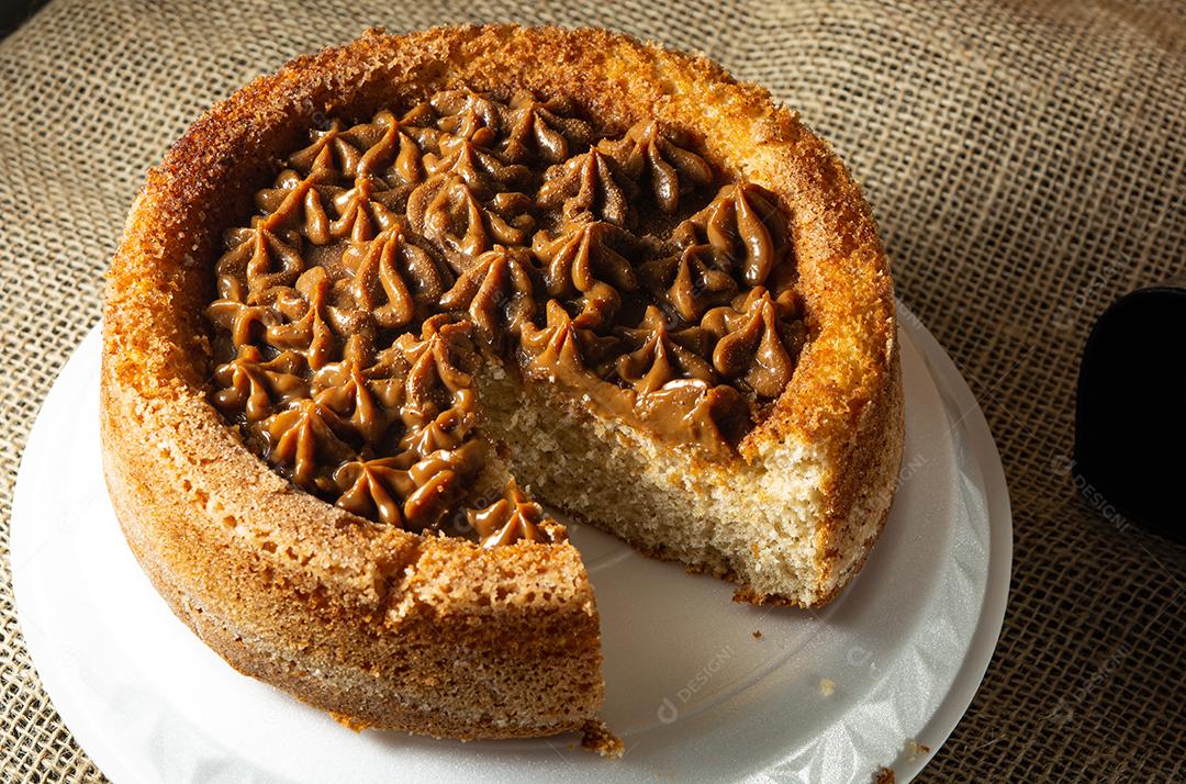 bolo de churros brasileiro típico com doce de leite, em uma mesa com pratos e café, café da manhã confortável ou cena de lanche