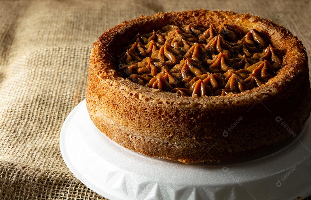 bolo de churros brasileiro típico com doce de leite, em uma mesa com pratos e café, café da manhã confortável ou cena de lanche