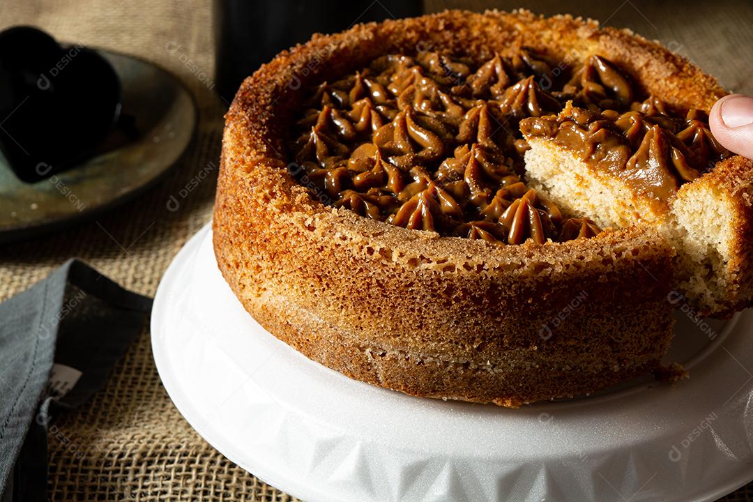 mão de homem cortando uma fatia de bolo de churros brasileiro