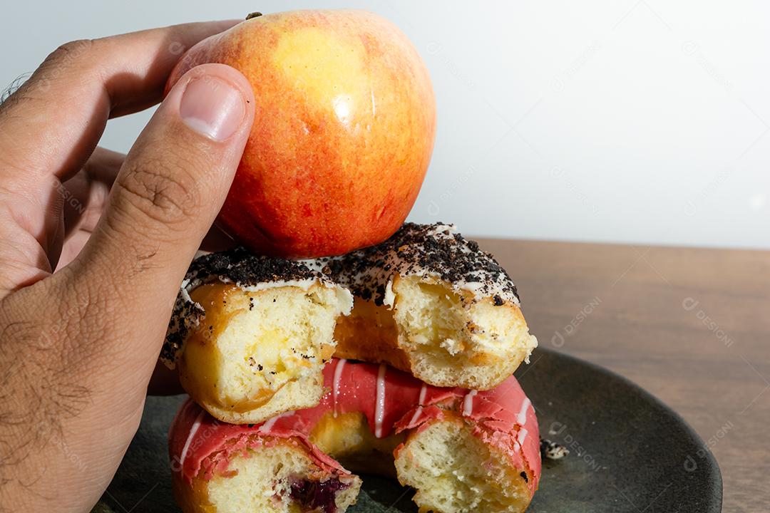 Bolinhos donuts everglazed com maçã sobre mesa madeira fundo branco