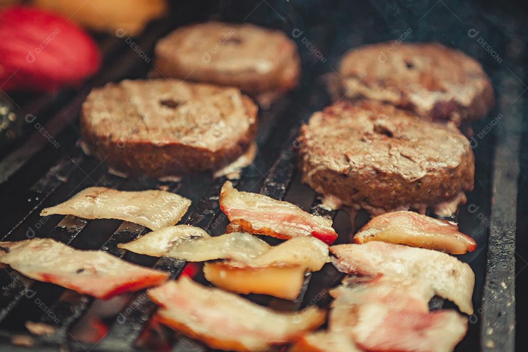 Chapa quente com hambúrguer e bacon em preparação