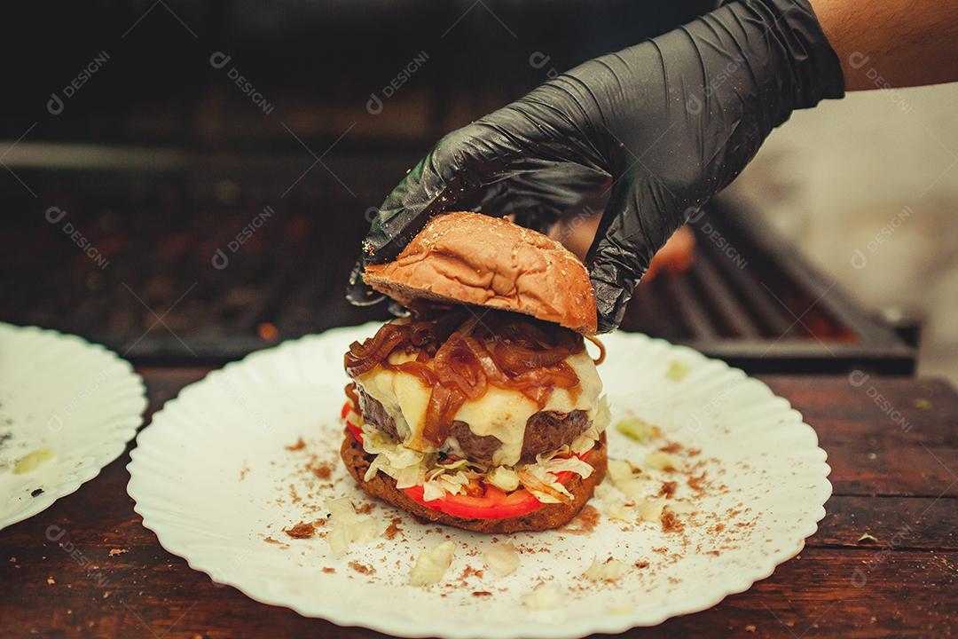 Prato branco com hambúrguer, cebola e pães em preparação
