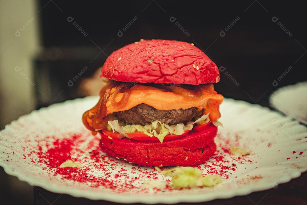 Prato branco com hambúrguer com pão da cor rosa