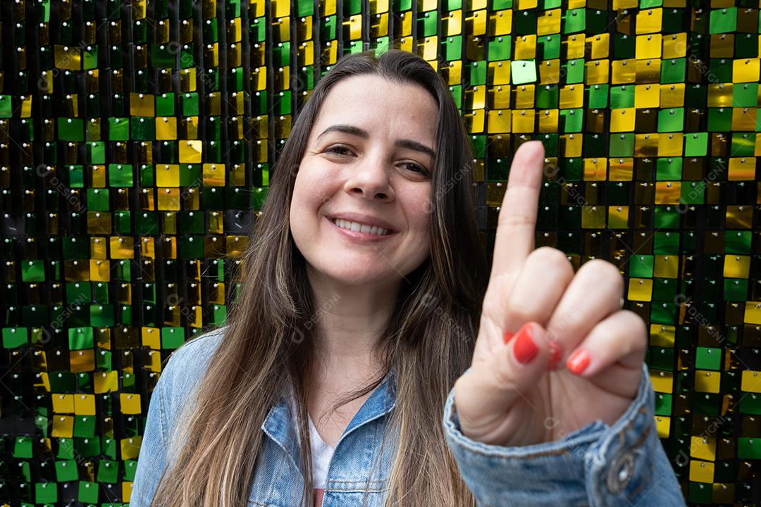 Mulher brasileira mostrando com a mão o número um em um backgr