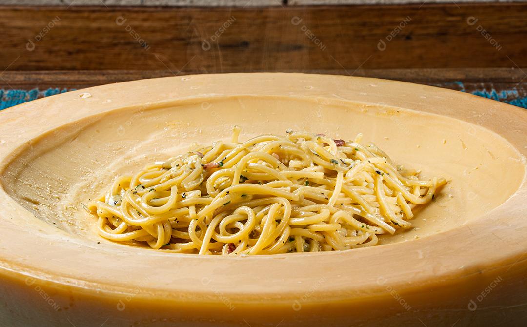 Espaguete com ovo, bacon e salsa, derretido dentro de uma almofada de grana