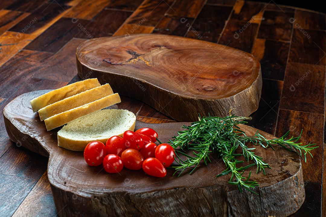 taboa  de madeira com pão cortado e tomate