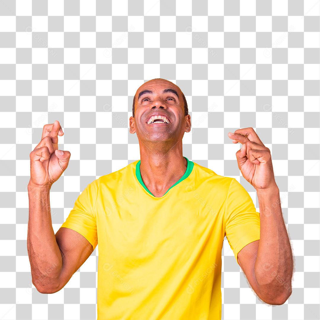 Torcedor brasileiro com os dedos cruzados desejando sorte