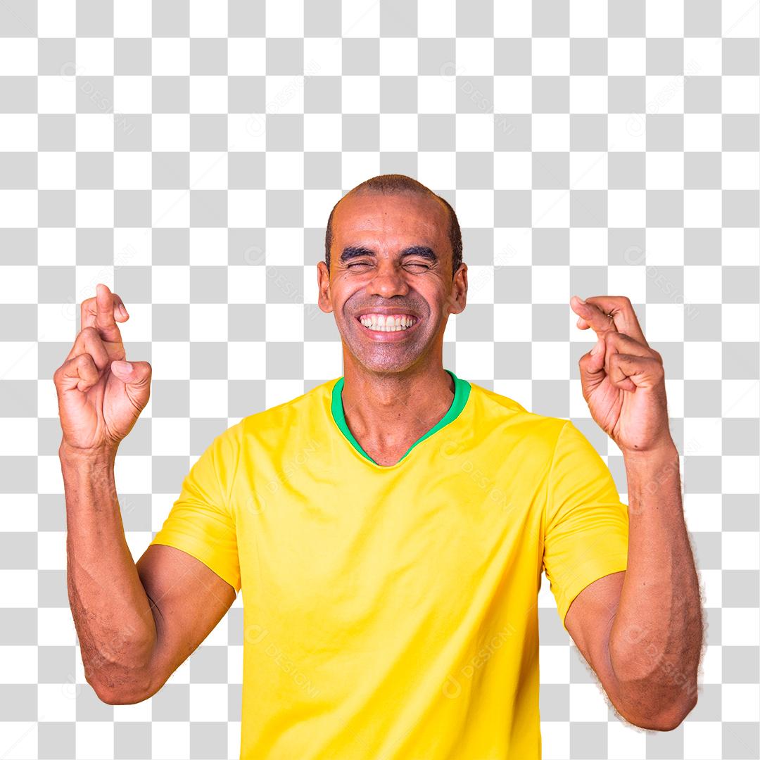 Torcedor brasileiro com os dedos cruzados desejando sorte