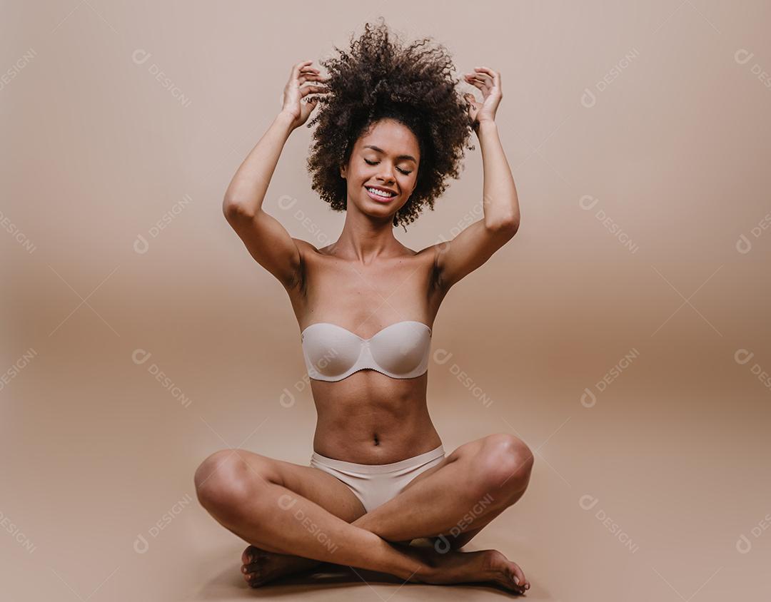 Jovem afro latina sorridente. Alegria, positivo e amor. Lindo cabelo estilo africano. Fundo pastel de estúdio.