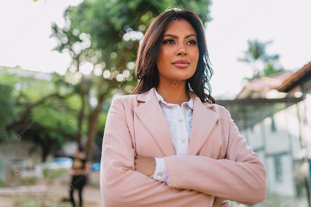 Retrato de uma mulher latina atraente andando no parque no outono em um dia ensolarado e sorrindo