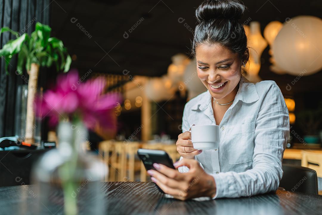 Mulher latina em um café bebendo café.