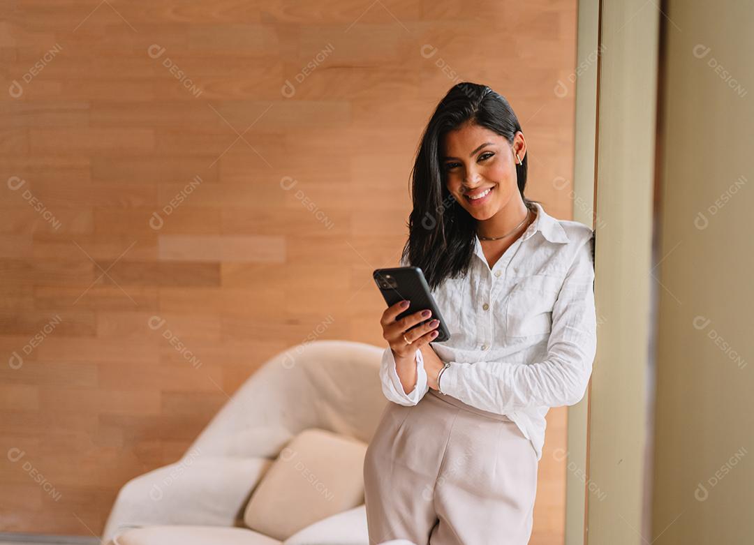 Linda garota latina usando seu celular.